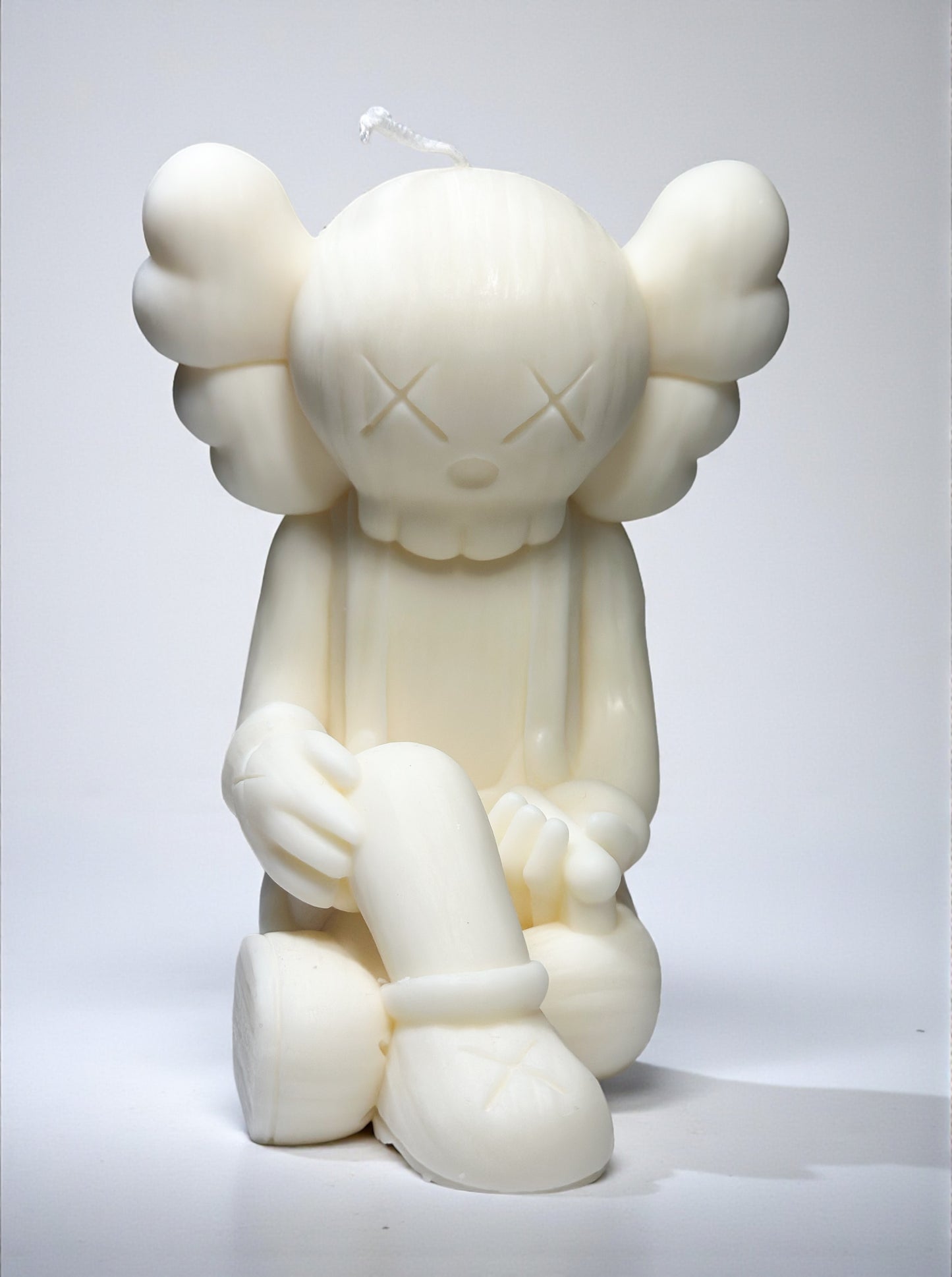 White kaws character candle on a white background
