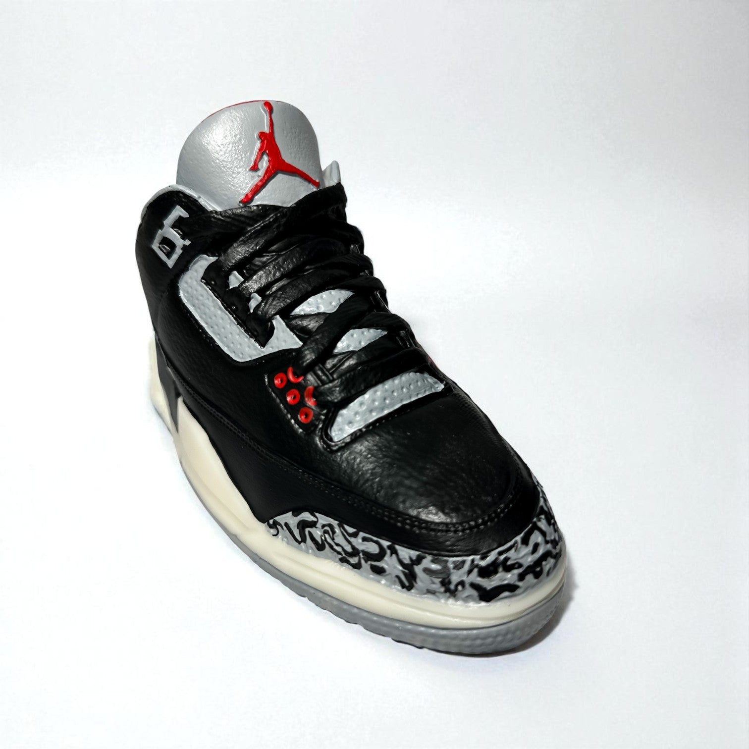 hand-painted black sneaker candle on white background.