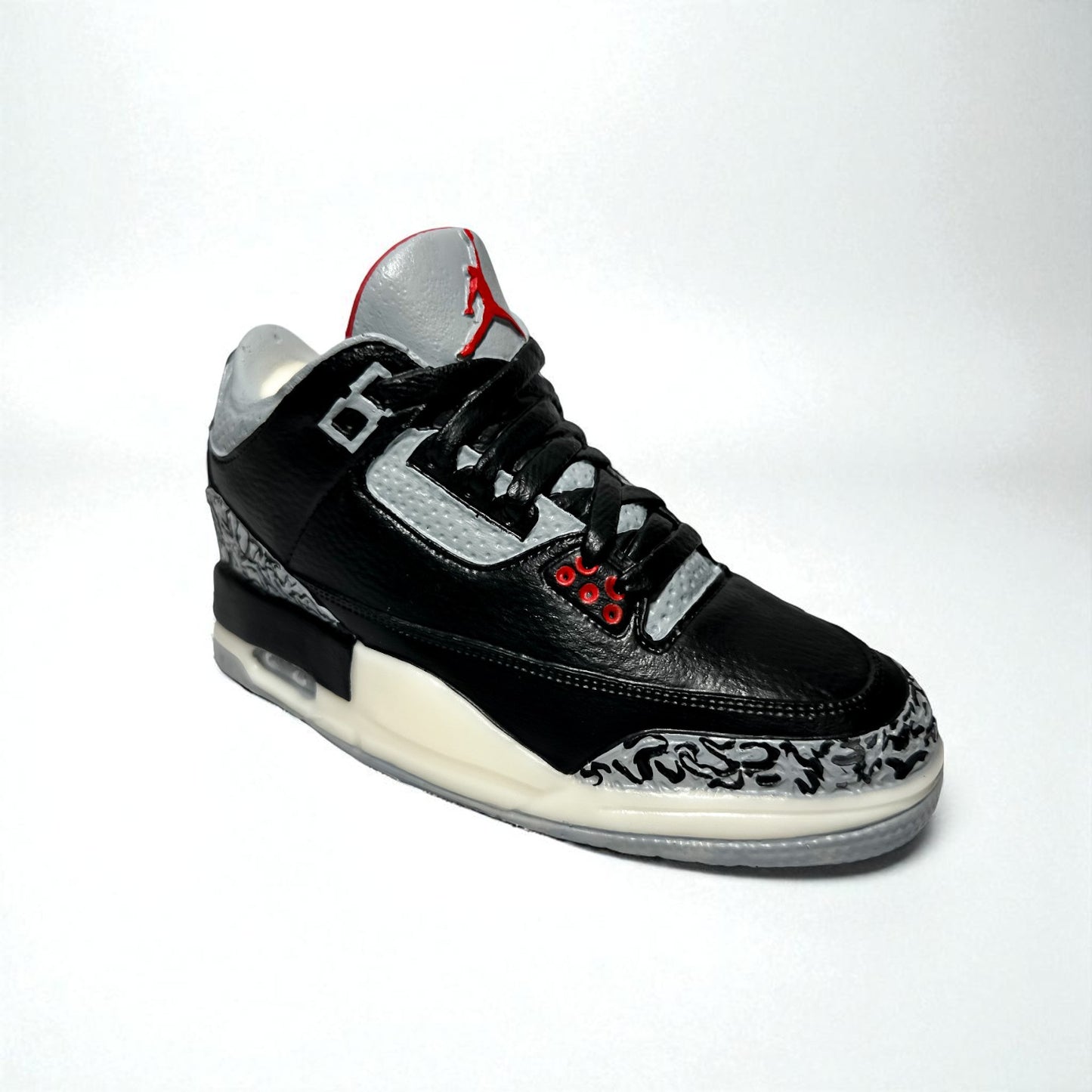 black cement 3 sneaker candle on white backdrop