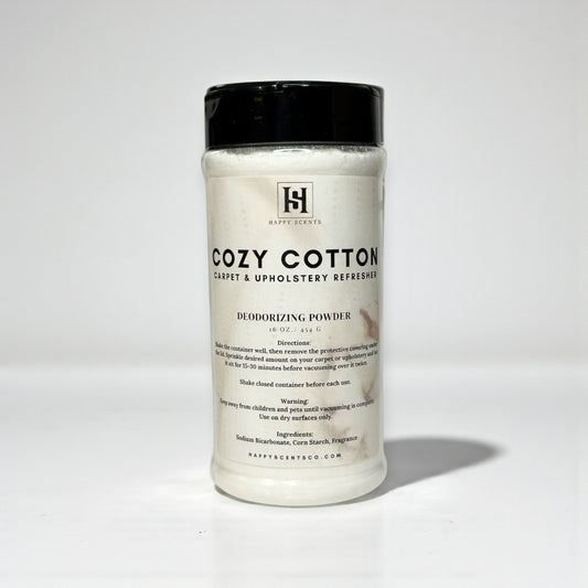 Plastic Clear Cylindrical Container of 'Cozy Cotton' deodorizing powder with a black lid on a white background