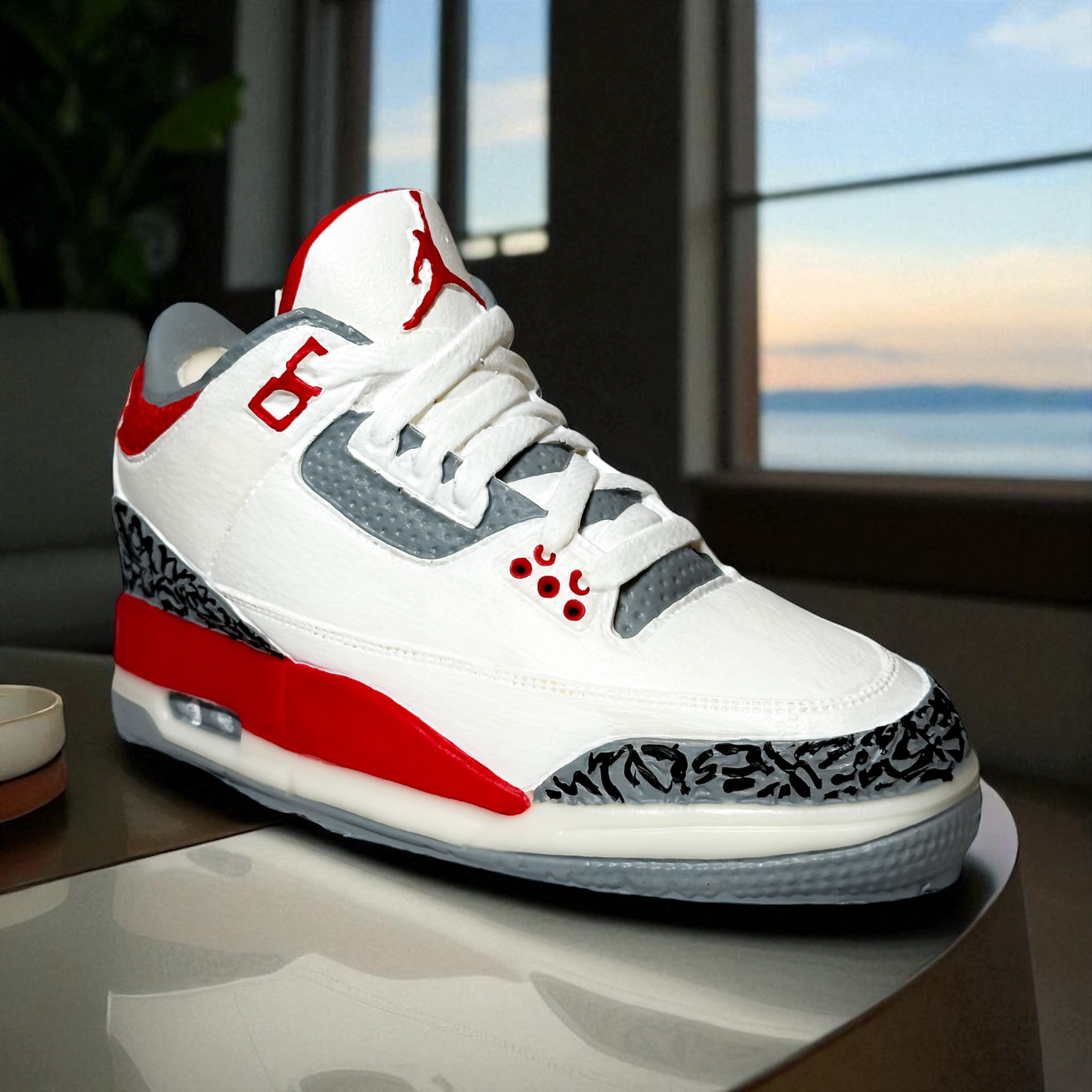 Fire Red 3 Inspired sneaker candle sitting on a side table. 