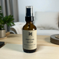 Matcha Glow room and linen mist bottle on a wooden surface with a blurred background