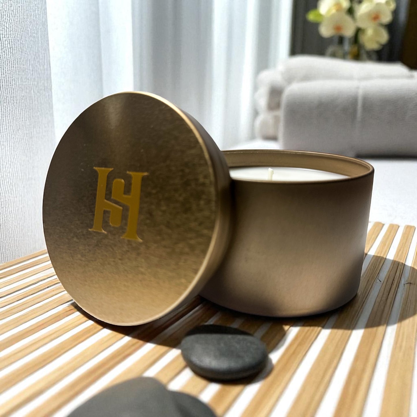 Travel tin Candle with a gold lid featuring Happy Scents logo on a wooden surface.