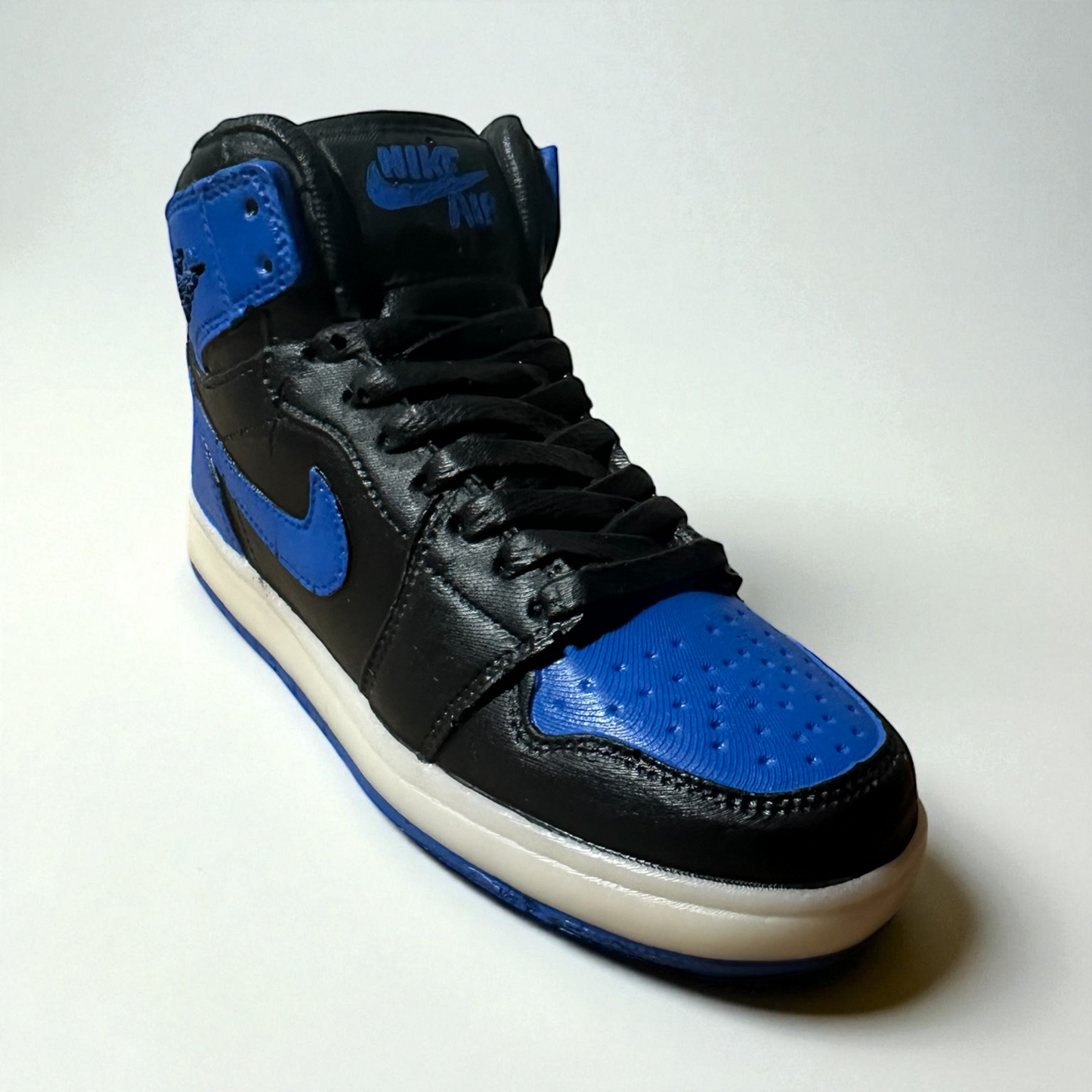 Black and blue high-top sneaker with a white sole on a light gray background