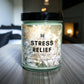 Candle jar labeled 'Stress Relief' on a table with a blurred indoor background